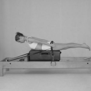 Lady doing, Pulling straps on Pilates reformer