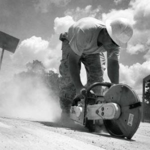 A construction worker using a concrete saw.