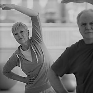Old older lady and man doing a side stretch.