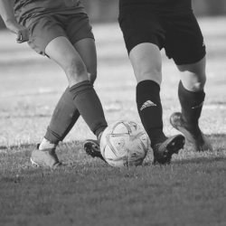 An image of two soccer players competing for the soccer ball